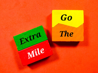 Business concept.Text Go The Extra Mile writing on colored block on a red background.
