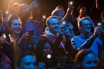 Fototapeta na wymiar Excited audience with smart phone flashlights cheering
