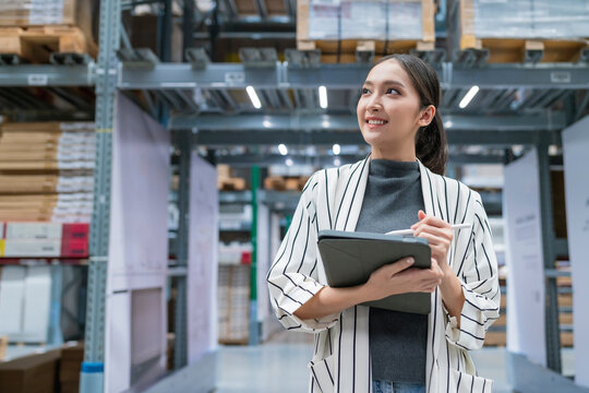 Portrait Of Asian Woman Business Owner Using Digital Tablet Checking Amount Of Stock Product Inventory On Shelf At Distribution Warehouse Factory.logistic Business Shipping And Delivery Service