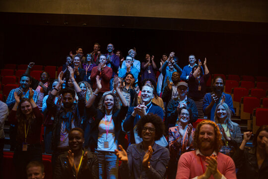 Smiling, enthusiastic woman cheering in audience