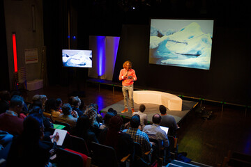 Male speaker on stage talking to audience
