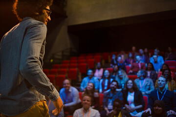 Male speaker on stage talking to audience