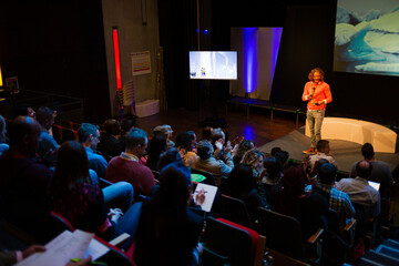 Male speaker on stage talking to audience