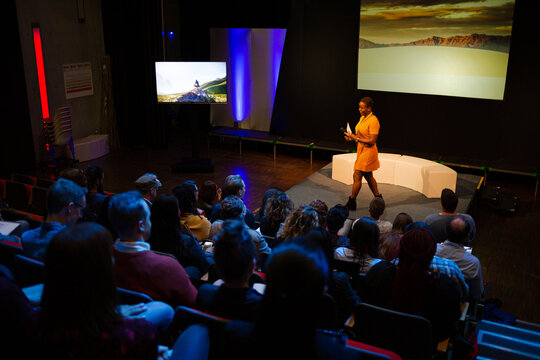 Female Speaker On Stage Talking To Audience