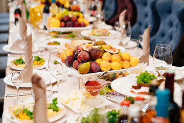 large festive table. a large plate with a fruit platter in the center. 