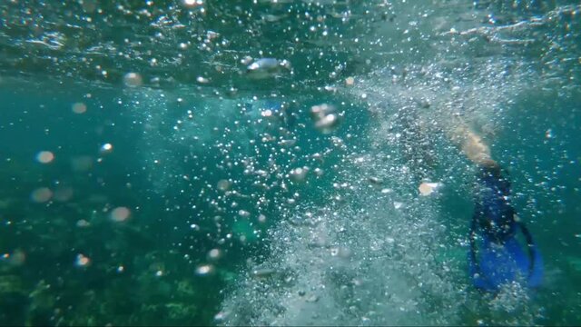 A snorkeler's flippers creating lots of bubbles while snorkeling in beautiful turquoise tropical water in the beautiful Riviera Maya, Mexico near Cancun and Tulum on vacation.