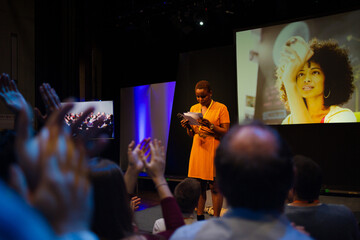 Female speaker on stage talking to audience