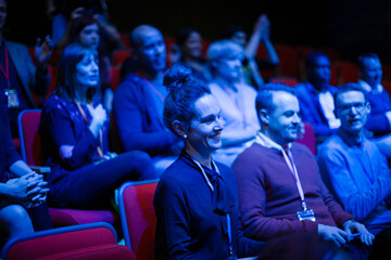 Audience clapping in dark room