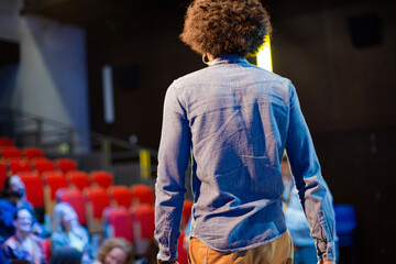 Male speaker on stage talking to audience