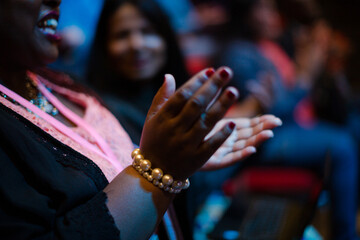 Audience clapping in dark room