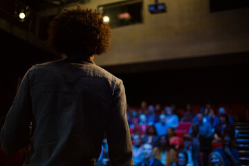 Male speaker on stage talking to audience