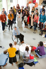 Audience watching male speaker in wheelchair talking on stage