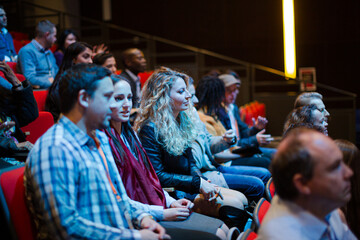 Man and woman with with smart phone in conference audience