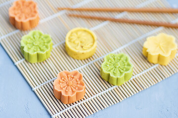 Flat lay of Chinese Festival dessert, Mid Autumn Festival Moon cake on gray concrete background and bamboo cover with chopsticks. Top view, overhead