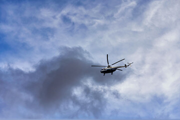 Flying helicopter on the background of clouds and blue sky