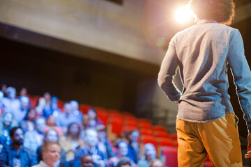 Audience watching male speaker on stage