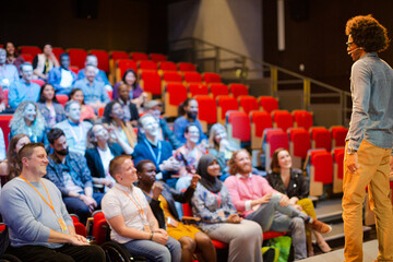 Audience watching male speaker on stage