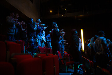 Audience clapping in dark room