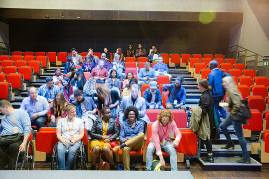 Audience arriving and sitting in auditorium - Powered by Adobe