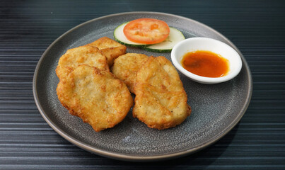 deep fried golden chicken nugget fritter with sauce on dark grey wood background dim sum halal menu