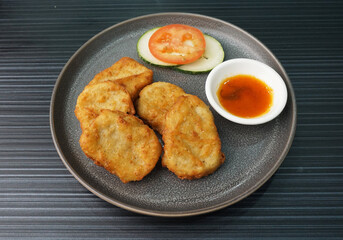 deep fried golden chicken nugget fritter with sauce on dark grey wood background dim sum halal menu