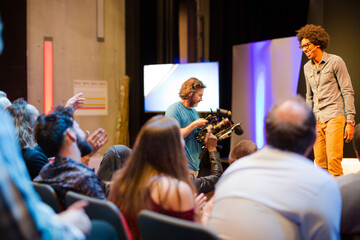 Audience watching male speaker on stage