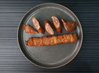 deep fried pork fish meat roll wrapped with bean curd skin ngohiang on dark grey wood background...