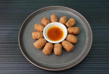 deep fried mini hot dog sausage luncheon meat with spicy sauce on dark grey wood background dim sum halal menu