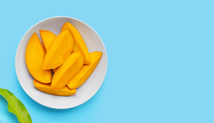 Tropical fruit, Mango on white plate on blue background. Top view