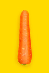 Fresh carrot on yellow background.
