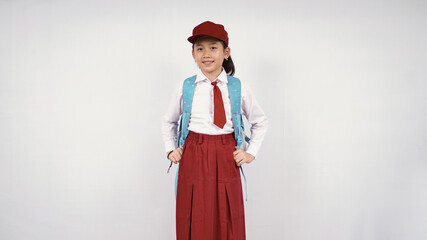 asian little girl wearing hat and school bag smiling happily on white background isolated