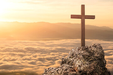 Silhouettes of crucifix symbol on top rock mountain with bright sunbeam and morning mist sunrise...