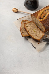 Sliced ready-made banana bread with honey on white plate