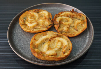 deep fried crispy golden fresh prawn fritter pan cake in round shape on dark grey wood background dim sum halal menu