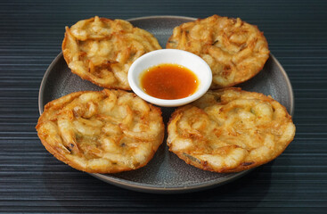 deep fried crispy golden fresh prawn fritter pan cake in round shape on dark grey wood background dim sum halal menu