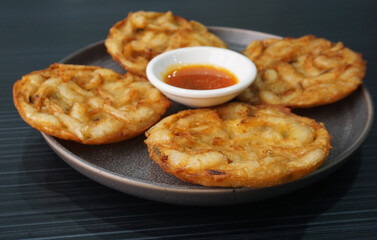 deep fried crispy golden fresh prawn fritter pan cake in round shape on dark grey wood background dim sum halal menu