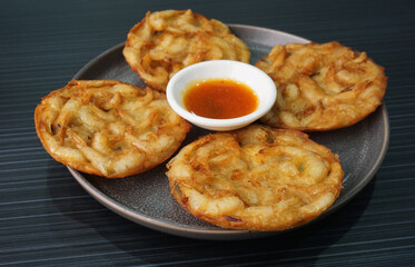 deep fried crispy golden fresh prawn fritter pan cake in round shape on dark grey wood background dim sum halal menu