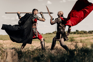 Battle between two ancient warriors in battle dress and cloaks.