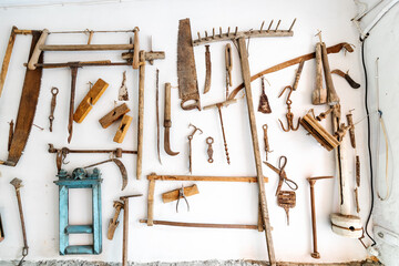 A lot of ancient wooden rural tools on the wall in the village