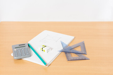 A desk table with equipment for mathematics assignment from geometry including: task pad notebook, rulers, pencils and calculator.