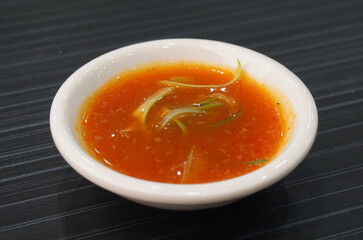 homemade garlic spicy chilli sauce in white plate on dark grey wood background dim sum halal menu