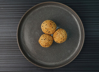 deep fried golden crispy sesame ball wrapped with sweet pandan lotus paste lava dessert in plate on...