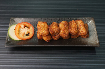 deep fried pork fish meat roll wrapped with bean curd skin ngohiang on dark grey wood background dim sum menu