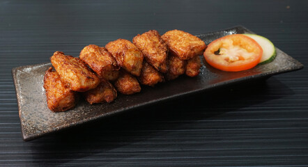 deep fried pork fish meat roll wrapped with bean curd skin ngohiang on dark grey wood background dim sum menu