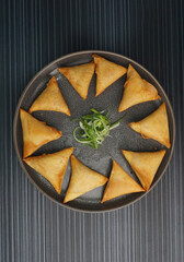 deep fried crispy yam taro spring roll samosa on dark grey wood background dim sum halal menu