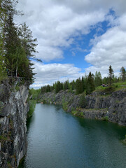 Fototapeta premium Top view of the cliffs, grotto and boats floating in the turquoise waters of Marble Canyon in Ruskeala Mountain Park on a summer day.