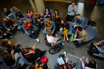 Attentive audience listening to female speaker in wheelchair