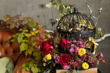 A close up of metal black cage with floral arrangement