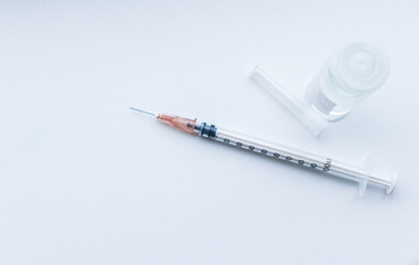 vaccine on a vial bottle and injection Syringe on a white table