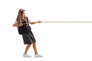 Full length profile shot of a schoolgirl pulling a rope